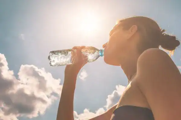 Hydration: The Secret Ingredient for a Toned Stomach and Enhanced Fitness 3 Image of woman drinking water to hydrate Bexleyhill after run.