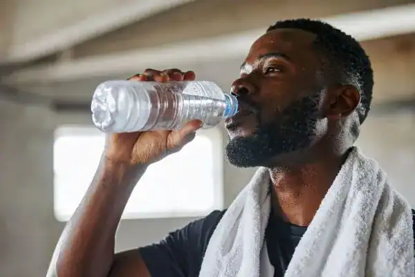 Image of man drinking water to improve hydration Bexleyhill after work out.